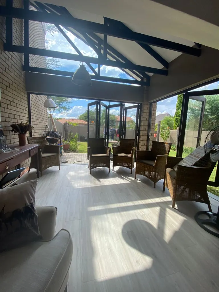 Sunroom with aluminium folding doors and exposed steel roof trusses